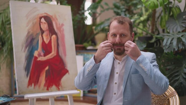 Painter pauses drawing to fix mustache