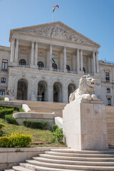 Fototapeta na wymiar Escultura de león y fachada de la Asamblea de la República en la ciudad de Lisboa, Portugal