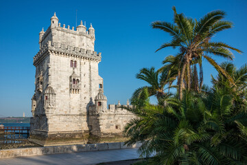 Fototapeta na wymiar Palmeras y vista de la histórica torre de Belem junto al río Tajo en Lisboa, Portugal