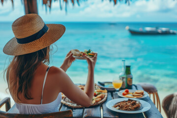 A woman eats food and enjoys the ocean view. Tropical vacation dining table. The concept of travel