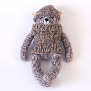 Knitted woolen bear in a sweater and hat