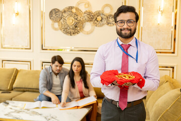 Bank Agent holding gold jewelery rapped in red cloth in hand. couple doing documentation process...