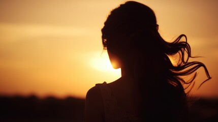 Silhouette of a woman with her hair blowing in the wind. Suitable for various themes and concepts