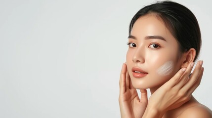 Serene Asian beauty applying a touch of skincare cream