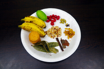 Tray of Ingredients Biscuits, Banana, Lemon, Bay Leaf, Cinnamon, Raisins, Almonds, Cardamom, Cloves, and Cherry Fruit 