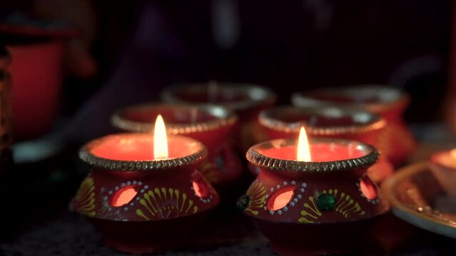 traditional diya lamps being lit with matches in clay earthenware pots hand painted with designs showing the festival of light diwali in India part of hindu religion