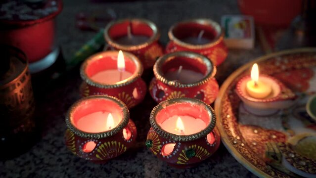 traditional diya lamps being lit with matches in clay earthenware pots hand painted with designs showing the festival of light diwali in India part of hindu religion