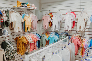Children's spring jumpsuits hang on a hanger at a children's clothing store