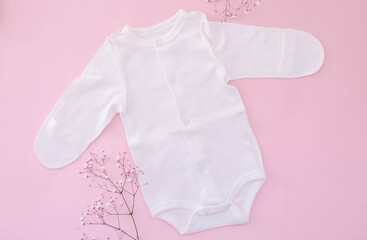 jumpsuit for a girl on a pink background with flowers. Spring clothes for the newborns