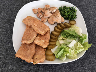 Homemade grilled chicken with grilled zucchini, green salad, cucumber pickles and parsley