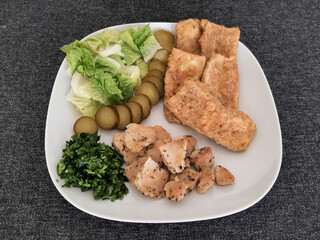 Homemade grilled chicken with grilled zucchini, green salad, cucumber pickles and parsley
