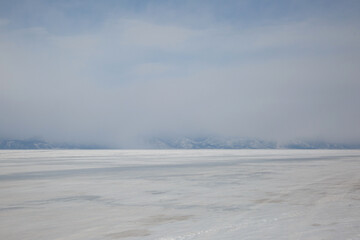 Fototapeta na wymiar Landscape with mountains in the haze and ice of Lake Baikal.