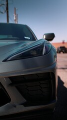 Vertical closeup of a modern gray sports car headlights