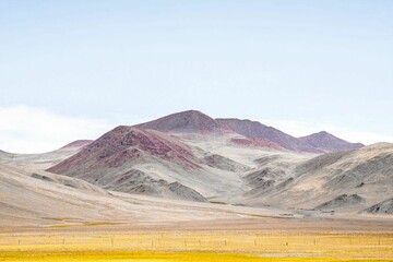 Mountainous landscape featuring a range of hills, highlighted in purple and yellow hues