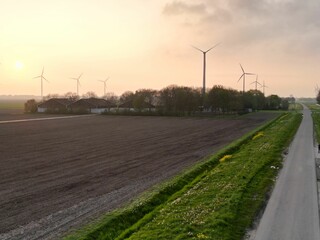 Aerial shot of a highway road in front of a series of wind turbines