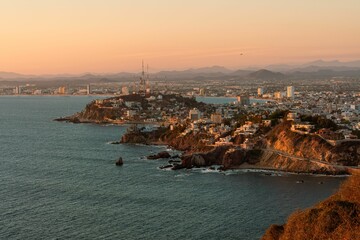 a bay that is by some mountains with a city below it