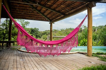 a pink hammock hangs on the porch next to an outdoor swimming pool