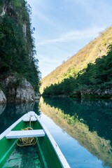 Scenic view of a boat sailing through a river in a green landscape