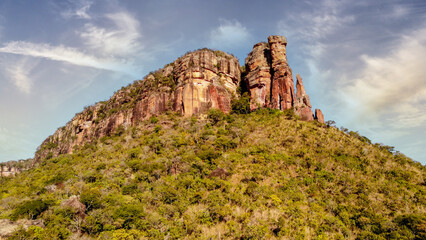 Stunning, sun-drenched landscape featuring rocky terrain and lush green shrubbery