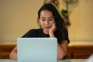 a woman is on the laptop computer in her hand, looking sad