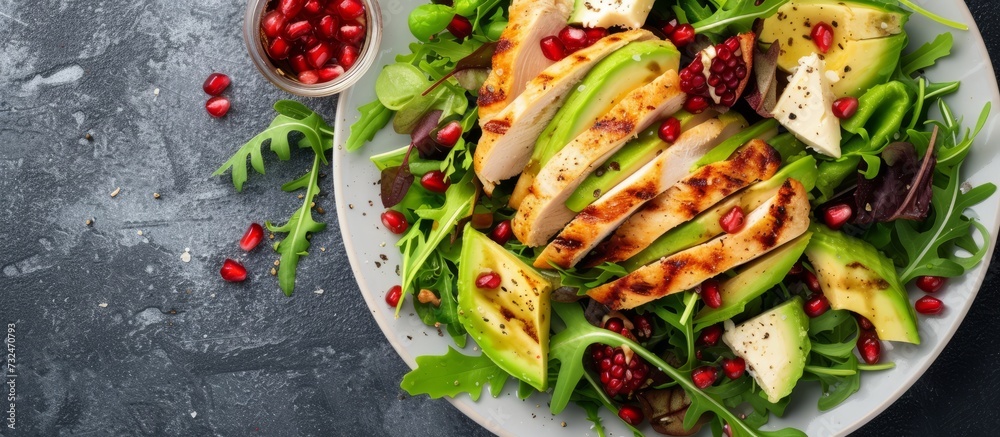 Canvas Prints a delicious plant-based salad recipe featuring chicken, avocado, pomegranate seeds, and lettuce serv