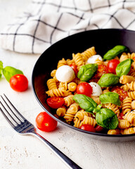 Organic Italian Chickpea Fusilli Pasta alla Caprese. Gluten-Free, Grain-Free, and Vegan Pasta Salad. Healthy Eating Concept.