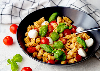 Organic Italian Chickpea Fusilli Pasta alla Caprese. Gluten-Free, Grain-Free, and Vegan Pasta Salad. Healthy Eating Concept.