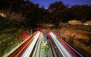 Train tracks at night illuminated by light trails.