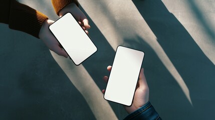 Two people exchanging contact information over smartphones with blank screens
