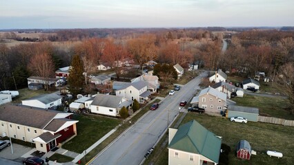 Fototapeta premium Aerial view of a small rural town with trees on a cloudy day