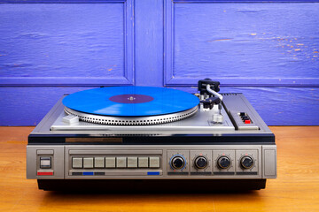 Vintage turntable vinyl record player with blue vinyl