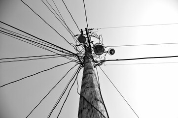 Wooden high-voltage power line pole in grayscale