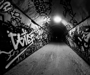 a tunnel with graffiti covering the walls and floors inside of it
