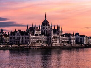 Hungarian Parliament Building on the banks of the Danube River at pink sunset