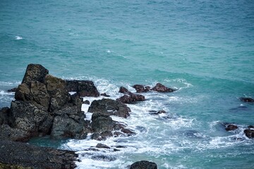 Fototapeta premium Large stones strewn along the beach eroded by the waves of the sea.