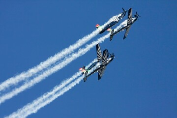 several airplanes flying in the air with smoke trails behind them