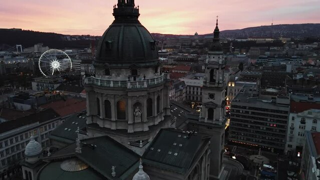 Aerial video of St. Stephen's Basilica at night with a christmas tree in the park, Hungary