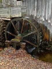 Closeup of an old wooden water wheel in motion, with the water running off of it