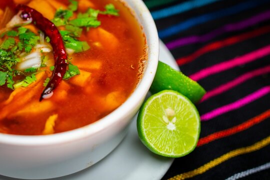 Closeup of a bowl of menudo rojo soup with lime in a Mexican Restaurant