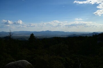 the sky is partly cloudy as it rises over the mountains