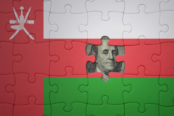 puzzle with the national flag of oman and usa dollar banknote. finance concept
