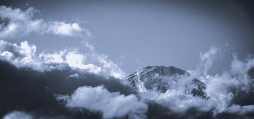 Scenic view of a mountain range covered with clouds in grayscale
