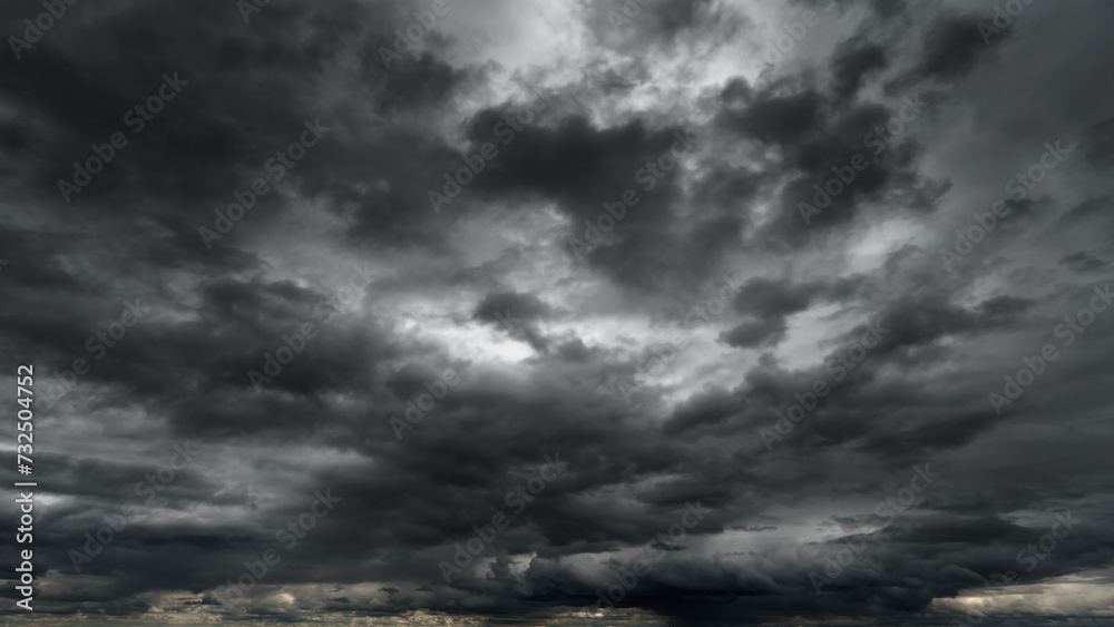 Wall mural dark dramatic sky with black stormy clouds before rain or snow as abstract background, extreme weath