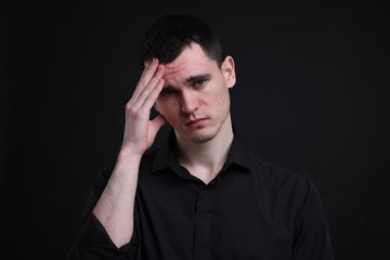 Portrait of sad man on black background