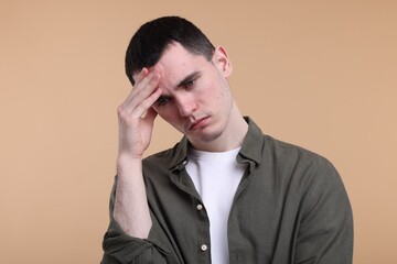 Portrait of sad man on beige background
