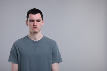 Portrait of sad man on grey background, space for text