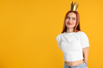 Fototapeta premium Beautiful young woman with princess crown on orange background, space for text