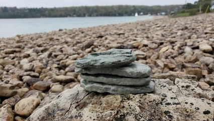 Fototapeta na wymiar rock stacking by the beach, with lake in background