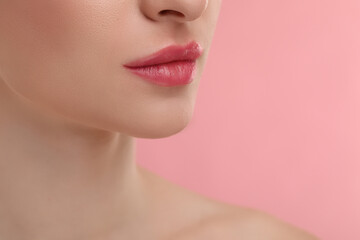 Obraz premium Young woman with beautiful full lips on pink background, closeup