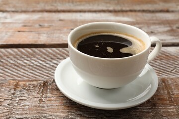 Cup of aromatic coffee on wooden table, closeup. Space for text